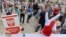 Demonstrators wearing gloves in the colors of the Polish flag and holding a booklet of the Polish constitution stage a protest outside the Presidential Palace, in Warsaw, Poland, July 3, 2018.