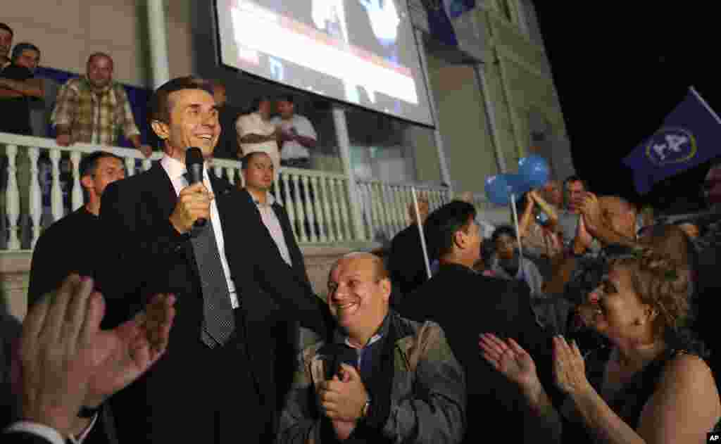 Georgian billionaire and opposition leader Bidzina Ivanishvili, left, celebrates with supporters at his office in Tbilisi Georgia, October 1, 2012.