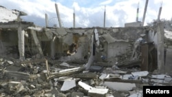Buildings damaged by what activists said were missiles fired by a Syrian Air Force fighter jet operated by forces loyal to Syrian President Bashar al-Assad are seen at Houla, near Homs December 6, 2012. 