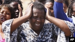 An unidentified woman cries as she protests against the police opening fire and killing striking mine workers a day earlier at the Lonmin Platinum Mine near Rustenburg, South Africa, August 17, 2012. 