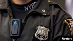 FILE - A police body camera is seen on an officer during a news conference on the pilot program of body cameras in the Queens borough of New York