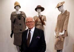 FILE - French fashion designer Pierre Cardin poses in front of his 1954-1956-1957 fashion creations in his museum called "Past-Present-Future" in Paris, Nov. 12, 2014.