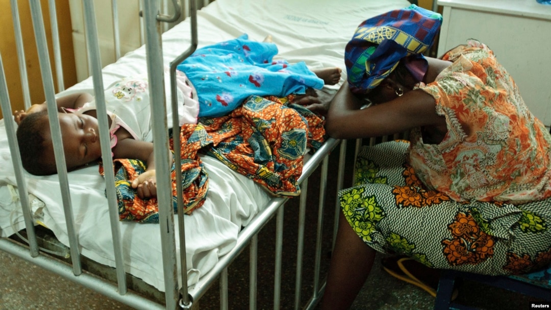 Hassana Ousmane rests her head against the bed where her 21-month-old daughter, Zeinab, suffering from malaria, rests at the Princess Marie Louise Children's Hospital in Accra, Ghana, April 25, 2012.
