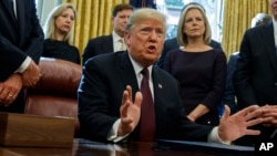 FILE - President Donald Trump answers a reporters question about the investigation of special counsel Robert Mueller during a signing ceremony of the "Cybersecurity and Infrastructure Security Agency Act," in the Oval Office of the White House, Nov. 16, 2018.