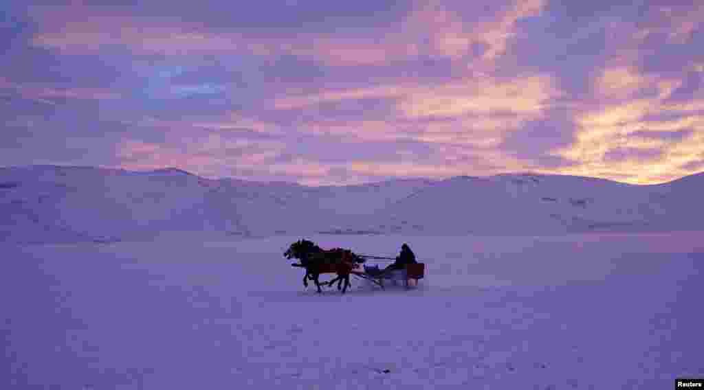A man rides a horse-drawn carriage on the frozen Cildir Lake in Kars province, eastern Turkey.