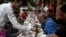 FILE: People eat Iftar, the breaking of fast meal, served for free on "charity tables" on a street during the first day of the holy month of Ramadan, in Cairo June 29, 2014. 