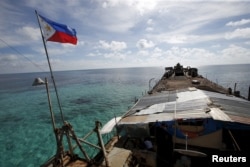 A Philippine flag flutters from BRP Sierra Madre, a dilapidated Philippine Navy ship that has been aground since 1999 and became a Philippine military detachment on the disputed Second Thomas Shoal, part of the Spratly Islands, in the South China Sea, Mar