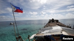 A Philippine flag flutters from BRP Sierra Madre, a dilapidated Philippine Navy ship that has been aground since 1999 and became a Philippine military detachment on the disputed Second Thomas Shoal, part of the Spratly Islands, in the South China Sea, Mar