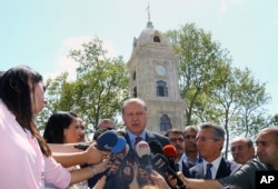 Turkey's President Recep Tayyip Erdogan, center, talks to members of the media after attending Friday prayers in Istanbul, Aug. 18, 2017.