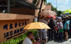 Parents pick up their children outside a Chinese-language primary school in Kuala Lumpur. (Photo: Zsombor Peter/VOA)