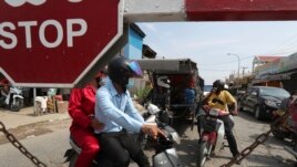 Residents are stopped near Phnom Penh International airport in Phnom Penh, Cambodia, Thursday, April 15, 2021. Cambodia’s leader on Wednesday said that the country's capital Phnom Penh will be locked down for two weeks following a sharp rise in COVID-19 cases.