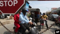 Warga dihentikan di dekat bandara internasional Phnom Penh ketika ibu kota Kamboja mulai menerapkan lockdown, Kamis (15/4). 