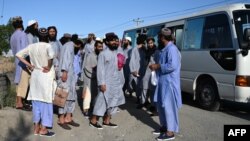 Tahanan Taliban keluar dari bus setibanya di Kabul, Afghanistan setelah mereka dibebaskan dari Penjara Bagram, 26 Mei 2020.