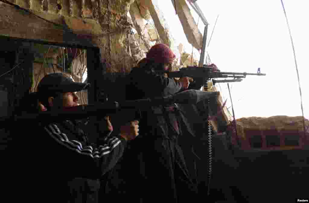 Free Syrian Army fighters with weapons stand guard at the frontline against forces loyal to Syrian President Bashar al-Assad in the Al-khalidiya neighborhood of Homs, December 4, 2012. 