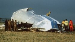 FILE - In this Dec. 23, 1988 photo, Scottish rescue workers and crash investigators search the area around the cockpit of Pan Am flight 103 in a farmer's field east of Lockerbie Scotland after a mid-air bombing killed all 259 passengers and crew,