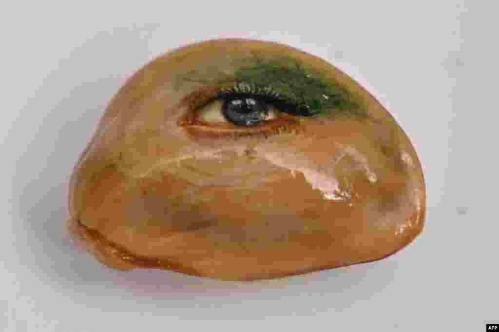 An eye painted on a fruit seed by Turkey&#39;s micro artist Hasan Kale in Istanbul, Turkey. The artist, also known as Turkish Microangelo in reference to Italian Renaissance sculptor and painter Michelangelo, has been hitting his brush onto tiny everyday obje