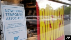 A sign advertises hiring of temporary associates at a Pier 1 retail store, which is going out of business, during the coronavirus pandemic, Aug. 6, 2020, in Coral Gables, Fla. 