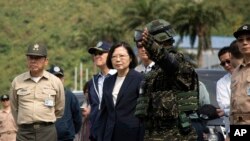 FILE - Taiwan's President Tsai Ing-wen, center, inspects at Su'ao naval station during a navy exercise in the northeastern port of Su'ao in Yilan County, Taiwan, Friday, April 13, 2018. Taiwan's government said Thursday that recent Chinese military drills aim to intimidate the island and are a threat to regional peace and stability.