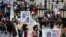 People walk past mayoral election campaign posters of Jorge Rodriguez from the United Socialist Party of Venezuela (PSUV) in Caracas, Dec. 4, 2013.