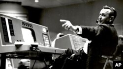 In this undated photo provided by NASA, Christopher Kraft, flight director during Project Mercury, works at his console inside the Flight Control area at Mercury Mission Control, in Houston.