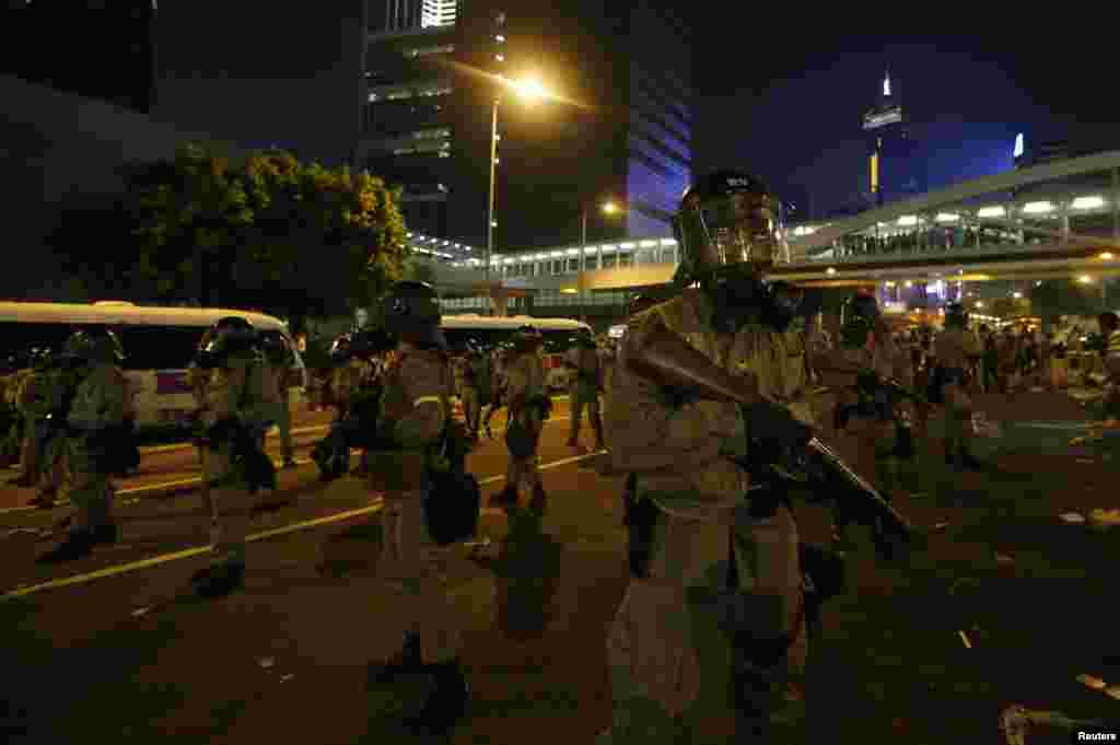 香港防暴警察手持催淚彈發射器與抗議者對峙。抗議者堵住了通往港府外面的金融中心區的主要道路。（2014年9月28日） 