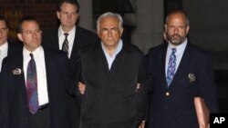 Dominique Strauss-Kahn (C), head of the International Monetary Fund (IMF), departs a New York Police Department precinct in New York late May 15, 2011.