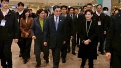 台湾行政院长卓荣泰(中)在桃园机场迎接行政院副院长郑丽君(右一)、行政院政务委员兼资深谈判代表杨珍妮(左四)回到台北。(2026年1月19日)