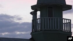 Member of Islamic sect calls for evening prayer from atop the house where followers lived in seclusion, Kazan, Russia, Aug. 9, 2012.