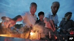 People burn incense and pray in front of the cenotaph dedicated to the victims of the atomic bombing at the Peace Memorial Park in Hiroshima, Japan, August 6, 2012.