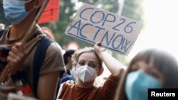 FILE - People take part in a march for climate justice while environment ministers meet ahead of Glasgow's COP26 meeting, in Milan, Italy, October 2, 2021.