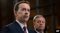 FILE - Acting U.S. Customs and Border Protection Commissioner John Sanders, left, joins Senate Judiciary Committee Chairman Lindsey Graham, R-S.C., right, on Capitol Hill in Washington, May 15, 2019.