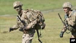 Commander of the 82nd Airborne Division General Richard D. Clarke, left, runs after jumping during a multi-national jump conducted by forces from the U.S., Great Britain and Poland on to a designated drop zone near Torun, Poland, Tuesday, June 7, 2016.