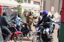 A soldier asks people to disperse outside Guillaume Ouedraogo army camp after Burkina Faso President Roch Kabore was detained at a military camp in Ouagadougou, Burkina Faso Jan. 24, 2022.