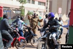 A soldier asks people to disperse outside Guillaume Ouedraogo army camp after Burkina Faso President Roch Kabore was detained at a military camp in Ouagadougou, Burkina Faso Jan. 24, 2022.