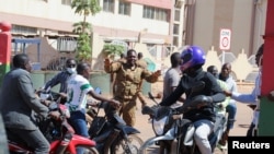 ARCHIVES - Un soldat demande à la population de se disperser devant le camp militaire Guillaume Ouedraogo après la détention du président du Burkina Faso, Roch Kabore, dans un camp militaire à Ouagadougou, Burkina Faso, le 24 janvier 2022.