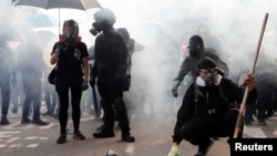 University students stand in a cloud of tear gas as they standoff with riot police at the Chinese University of Hong Kong, Hong Kong, China November 12, 2019. (REUTERS/Tyrone Siu)