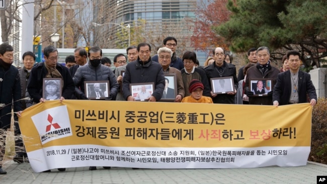 2018年11月29日，韩国首尔，日本强迫劳工受害者及其家人抵达最高法院。牌子上写着“三菱重工向受害者道歉和赔偿”。