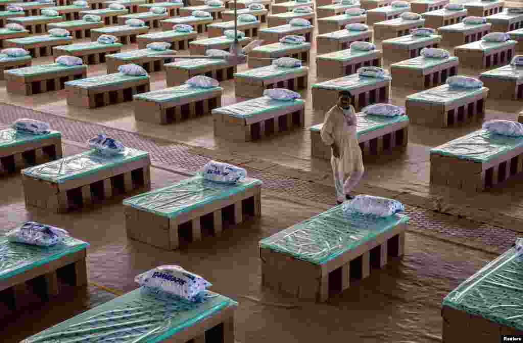 A volunteer walks past disposable beds made out of cardboard at the campus of Radha Soami Satsang Beas, a spiritual organization, where a coronavirus disease care center has been constructed for the patients, in New Delhi, India.