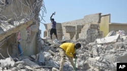 Scavengers work at the scene of a collapsed building in suburban Abuja, Nigeria, Oct. 28, 2024.