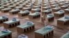 A volunteer walks past disposable beds made out of cardboard at the campus of Radha Soami Satsang Beas, a spiritual organization, where a coronavirus disease care center has been constructed for the patients, in New Delhi, India.