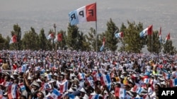 Rwandan Patriotic Front supporters wave party flags as they listen to remarks from incumbent President Paul Kagame during a campaign rally in Kigali, on July 12, 2024.