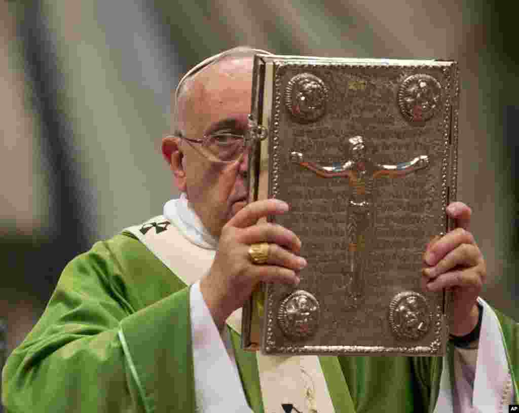 Le pape François hisse l&rsquo; Evangile lors d&rsquo;une messe en la basilique Saint-Pierre au Vatican, le 5 octobre 2014, pour ouvrir le Synode extraordinaire sur la famille. (AP Photo / Alessandra Tarantino) 