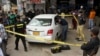 FILE - Investigators examine a damaged car at the site of a shooting incident, in Karachi, Pakistan, July 28, 2021. Gunmen riding on a motorcycle fired into the car that was carrying two Chinese workers.