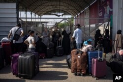 Warga Palestina menunggu untuk menyeberang ke Mesir di Rafah, Jalur Gaza, pada Rabu, 1 November 2023. (Foto: AP/Fatima Shbair)