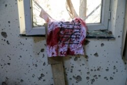 FILE - A bloodstained Taliban flag is seen on the window inside Kabul University after a deadly attack in Kabul, Afghanistan, Nov. 3, 2020.