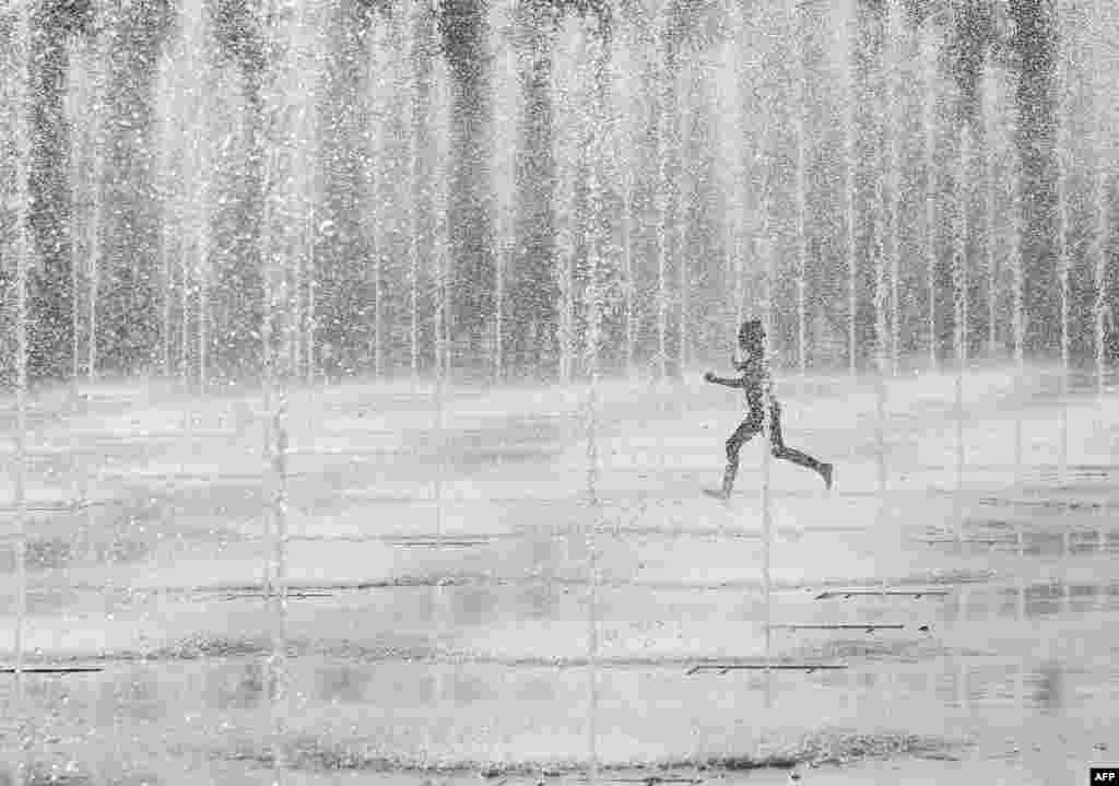 A child runs among a newly opened water installation between the "National Theatre of Nice" and the "Promenade des Anglais", in Nice, southeastern France.