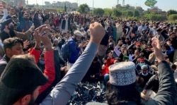 Supporters of Tehreek-e-Labaik Pakistan, a religious political party, chant slogans while they block a main highway during an anti-France rally over the remarks of French President Emmanuel Macron, in Islamabad, Pakistan, Nov. 16, 2020.