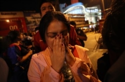 A woman who was able to get out of Terminal 21 Korat mall gestures with her hands on her face in Nakhon Ratchasima, Thailand, Feb. 9, 2020. A soldier who holed up in the mall shot multiple people on Feb. 8, killing at least 21.