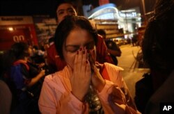 A woman who was able to get out of Terminal 21 Korat mall gestures with her hands on her face in Nakhon Ratchasima, Thailand, Feb. 9, 2020. A soldier who holed up in the mall shot multiple people on Feb. 8, killing at least 21.