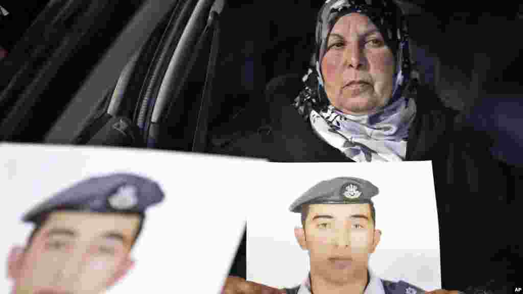 A woman holds a picture of her son, Jordanian pilot Lt. Mu'ath al-Kaseasbeh, who is held by Islamic State group militants, in Amman, Jordan, Jan. 27, 2015.